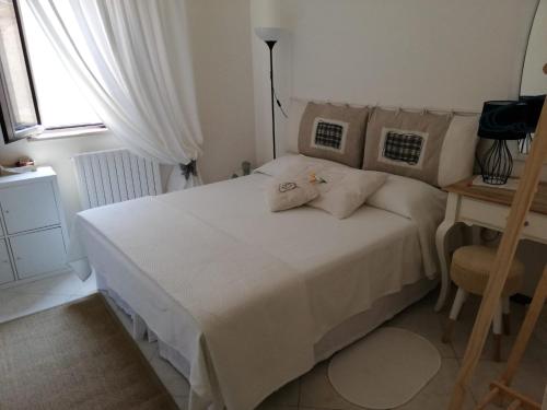 ein Schlafzimmer mit einem weißen Bett und einem Fenster in der Unterkunft Il Vicolo di Ripa B&b in Ripatransone