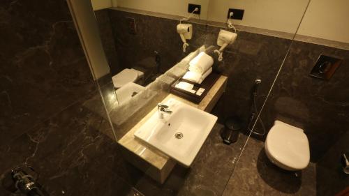 a bathroom with a sink and a toilet at The Vern at BLVD in Nashik