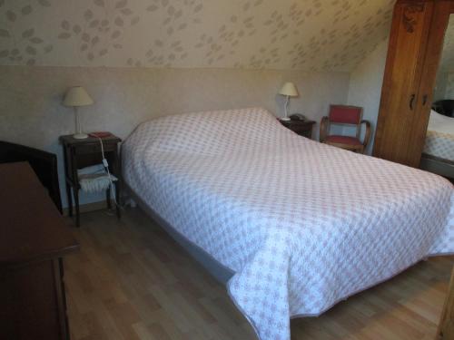 1 Schlafzimmer mit einem weißen Bett und 2 Stühlen in der Unterkunft 3 Rue Vicaire in Contalmaison
