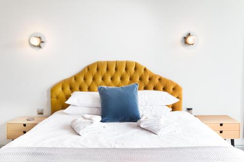 a bed with a blue pillow and white pillows at The Lerryn in Falmouth