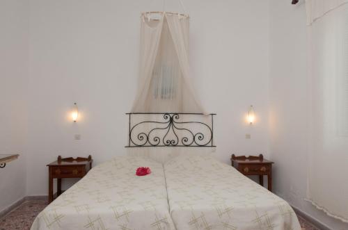 a bedroom with a white bed with a red rose on it at Andriani's Guest House in Mýkonos City