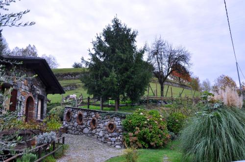 a garden in front of a stone house at Agriturismo Barcola in Grandola ed Uniti