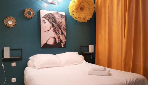 リールにあるLittle Suite - Pénélopeのベッドルーム1室(ベッド1台付)が備わります。壁に2枚の写真が飾られています。