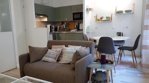 un salon avec un canapé et une table dans l'établissement Little Suite - Pénélope, à Lille