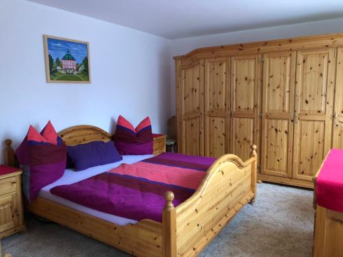 Schlafzimmer mit einem Holzbett und Holzschränken in der Unterkunft Fewo Radebeul Altkötzschenbroda in Radebeul