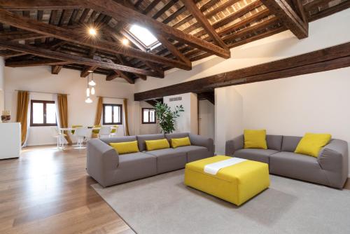 a living room with two couches and a yellow stool at Palazzo Vendramin Costa in Venice