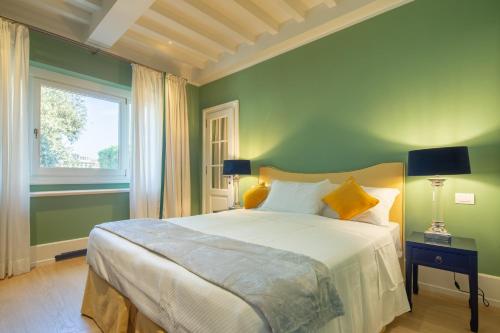 a green bedroom with a bed and a window at Villoresi Mansion in Florence