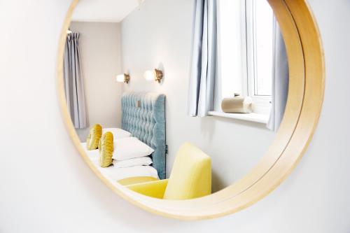 a mirror in a room with a chair and a couch at The Lerryn in Falmouth