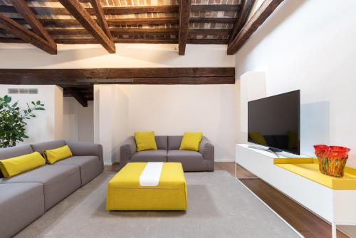 a living room with a couch and a tv at Palazzo Vendramin Costa in Venice