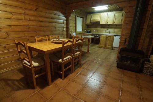 a kitchen with a wooden table and chairs and a stove at Chalé | Penhas da Saúde - Serra da Estrela in Penhas da Saúde