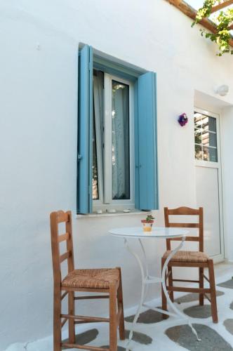 a table and two chairs sitting next to a window at Andriani's Guest House in Mýkonos City