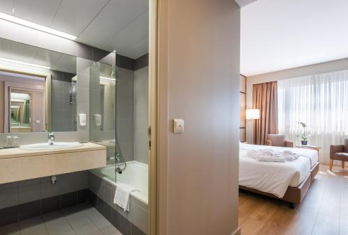 a hotel room with a large bed and a large mirror at Portus Cale Hotel in Porto