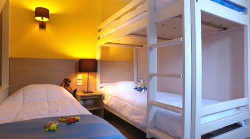 サン・ラリー・スランにあるVVF Saint-Lary-Soulan Hautes-Pyrénéesのベッドルーム1室(二段ベッド2組、人形付)