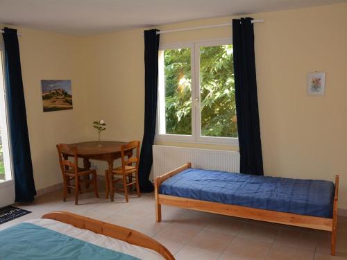 a bedroom with a bed and a table and a window at Domaine de Courbieres in Laurac