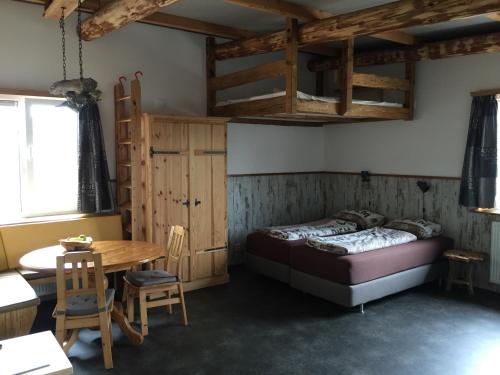 a bedroom with a bed and a table and a desk at De Droomhut in Den Hoorn