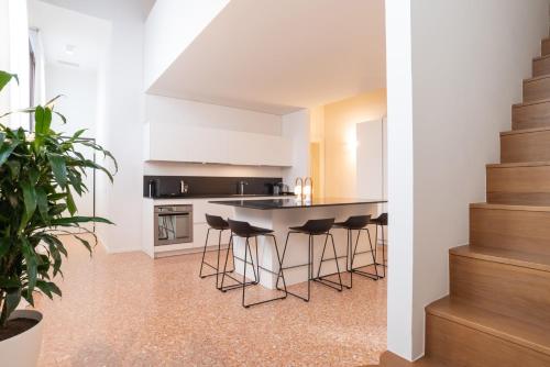 a kitchen with a island with bar stools at Palazzo Vendramin Costa in Venice