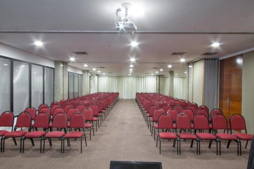 an empty room with red chairs in a hall at Alven Hotel by Slaviero Hotéis in Joinville