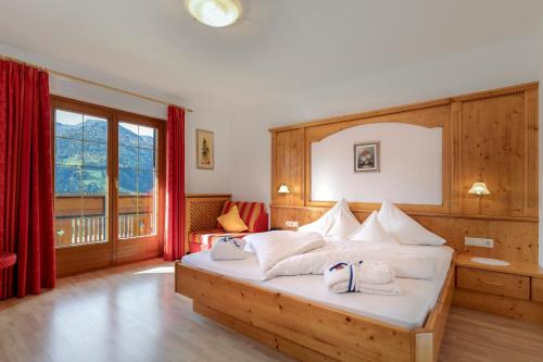 ein Schlafzimmer mit einem Bett und einem großen Fenster in der Unterkunft Hotel Kronhof in Moos in Passeier
