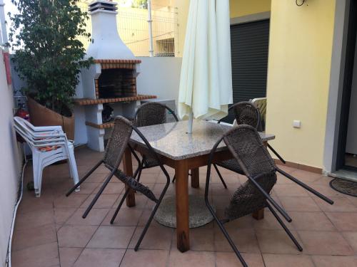 a table and chairs on a patio with a fireplace at Ria Apartments in Olhão