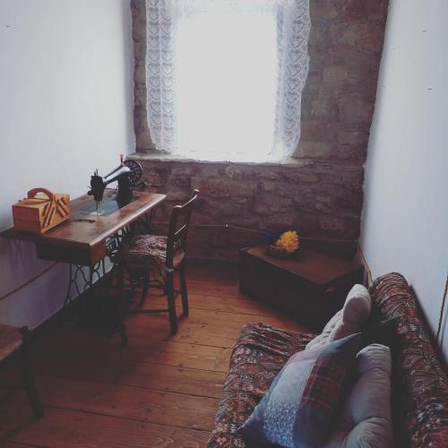 a living room with a table and a couch and a window at Casa museo "Sa domu de ziu Antoneddu" in Tuili