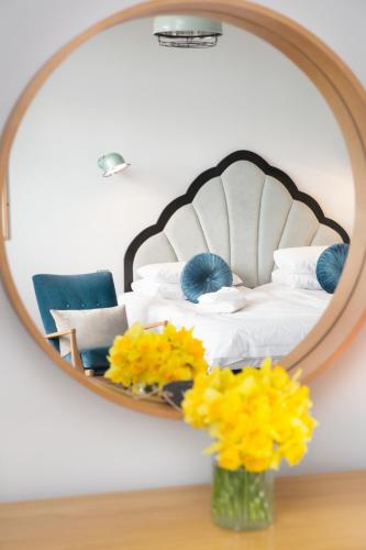a bedroom with a mirror and a bed with yellow flowers at The Lerryn in Falmouth