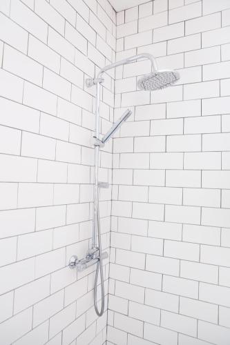 a shower in a bathroom with white tiles at The Lerryn in Falmouth