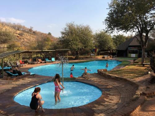 un grupo de personas jugando en una piscina en Mabalingwe Elephant Lodge, en Bela-Bela
