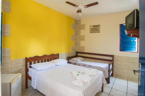 1 dormitorio con 2 camas y TV de pantalla plana en Pousada Lua Clara, en Paraty