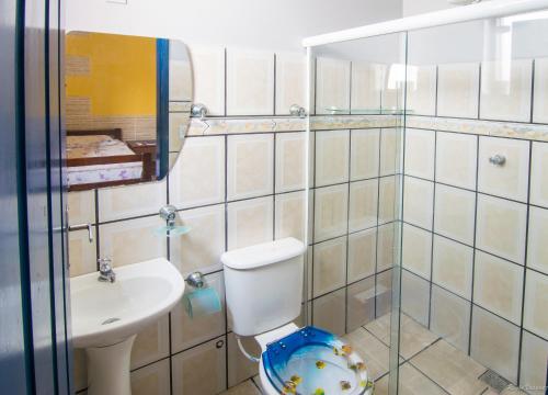 a bathroom with a toilet and a sink and a mirror at Pousada Lua Clara in Paraty