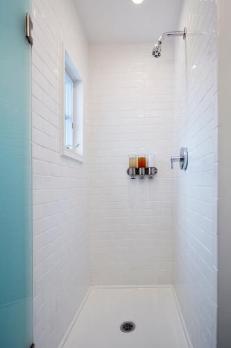 a white bathroom with a shower with a glass door at Station Inn Pawling in Pawling
