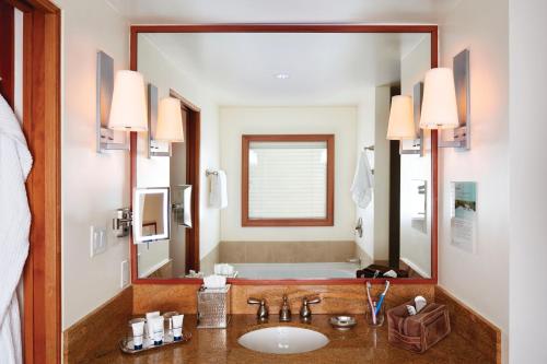 La salle de bains est pourvue d'un lavabo et d'un grand miroir. dans l'établissement Pan Pacific Whistler Village Centre, à Whistler