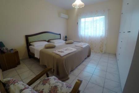 a bedroom with a bed and two chairs and a window at Oasis of CalmnessΕ in Ardánion