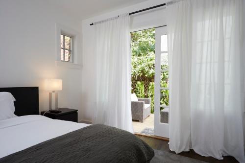 a bedroom with a bed and a sliding glass door at Station Inn Pawling in Pawling