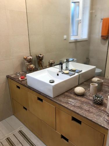 a bathroom counter with a white sink and a mirror at BS VILLAS RC PORTO in Porto