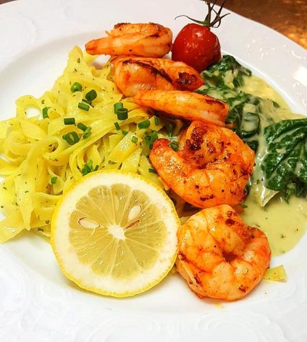 a plate of food with shrimp pasta and vegetables at Forsters Schwarzwald Hof - Resort-Hotel&Pension in Feldberg