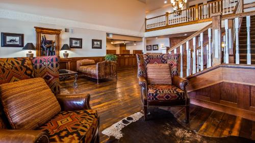 a living room with chairs and a stair case at Best Western Newberry Station in La Pine