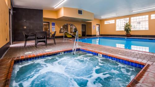 a large indoor pool with a table and chairs next to it at Best Western Newberry Station in La Pine