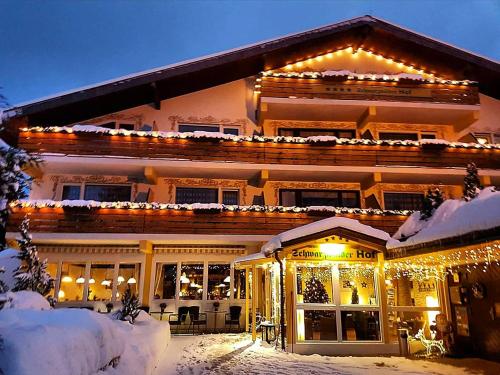 a house covered in christmas lights in the snow at Forsters Schwarzwald Hof - Resort-Hotel&Pension in Feldberg