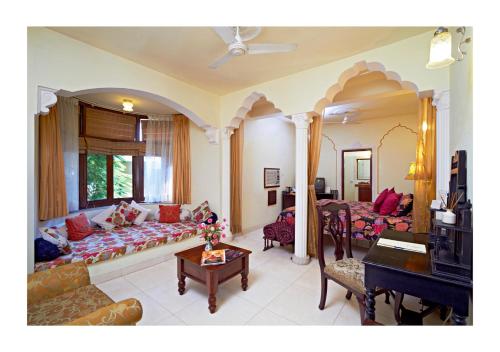 a living room with a couch and a piano at Dera Rawatsar - Heritage Hotel in Jaipur