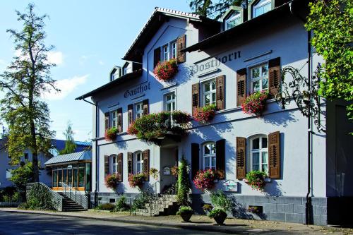 un edificio bianco con fioriere alle finestre di Posthorn a Ühlingen-Birkendorf