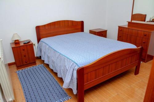 een slaapkamer met een houten bed en 2 nachtkastjes bij Hospedaria Santa Cruz in Seia