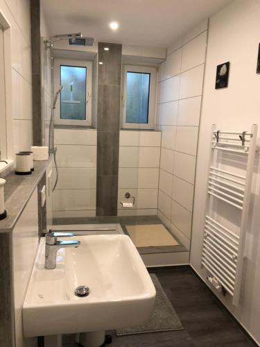 a white bathroom with a sink and a shower at Wohlfühlen In der Luft in Wesel