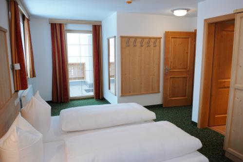 a room with two white stools in a room at Bacherhof in Sankt Anton am Arlberg