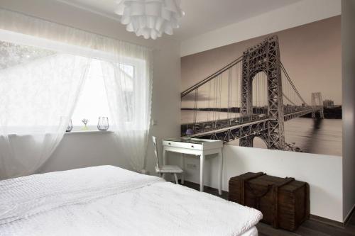 a bedroom with a bed and a desk and a bridge at Zur alten Rebe Ferienhaus und Weingut in Konz