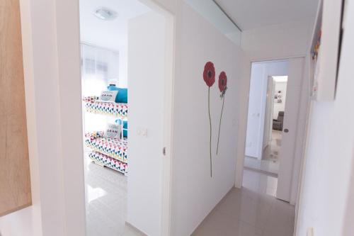 a room with a white wall with flowers on the wall at Apartamento Postman in Arenales del Sol