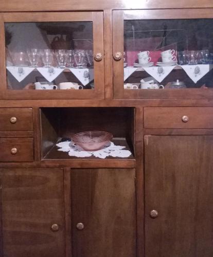 a wooden cabinet with a bowl inside of it at Casa museo "Sa domu de ziu Antoneddu" in Tuili