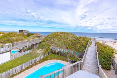 a view of the beach from the balcony of a beach house at Paradise Found - Nags Head MP 16.5, Oceanfront, Ocean & Sound Views, Pool, Hot Tub, Pets OK in Nags Head