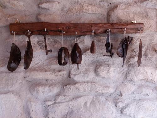 a group of shoes hanging on a wall at Casa museo "Sa domu de ziu Antoneddu" in Tuili