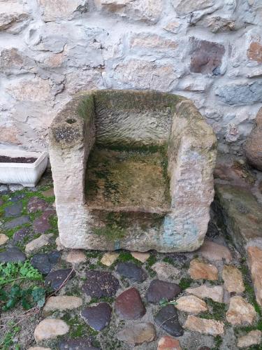 a stone bench sitting next to a stone wall at Casa museo "Sa domu de ziu Antoneddu" in Tuili