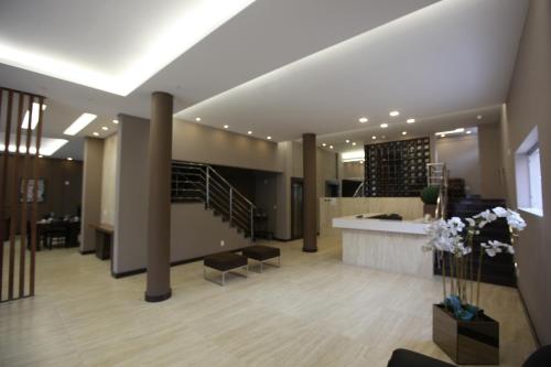 a lobby with a staircase in a building with pillars at HOTEL ALVORADA in Leopoldina